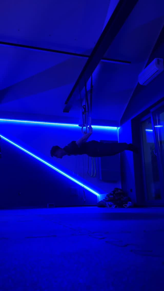 Trening na kółkach gimnastycznych wieczorem, sala w niebieskim świetle listew LED